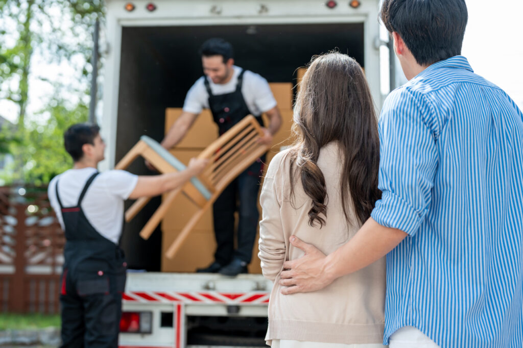 Operarios de mudanzas profesionales embalando muebles con protección especial.